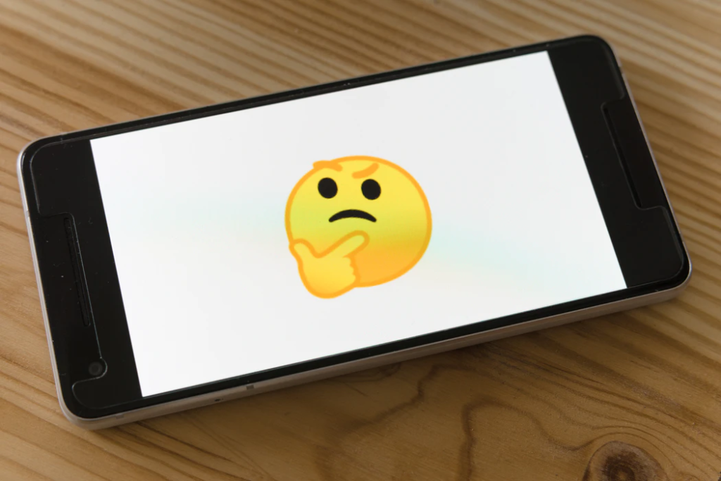 Cell phone with a picture of a concerned emoji